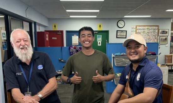 Three men smiling at the camera in a seafarer centre