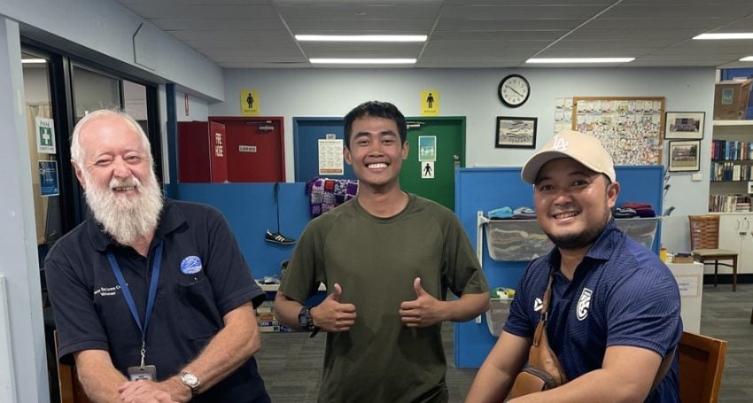 Three men smiling at the camera in a seafarer centre