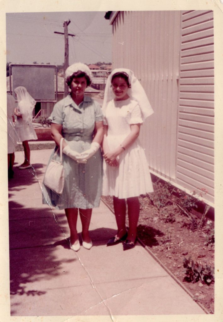 Two women pose for a photograph outside in anticipation of a Confirmation service