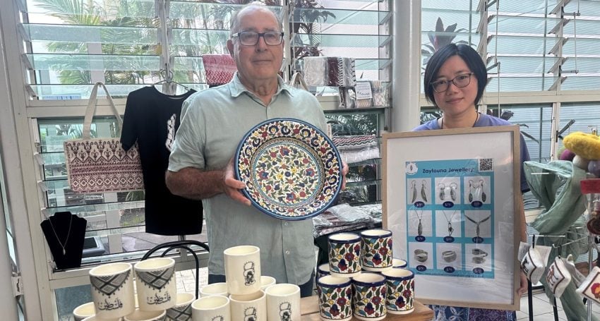 A man and a woman selling ceramics and jewellery at a stall