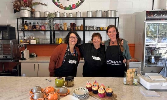 Three women stand in the My Dilly Bag kitchen posing for a photograph
