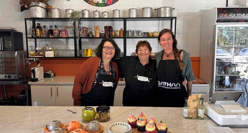 Three women stand in the My Dilly Bag kitchen posing for a photograph