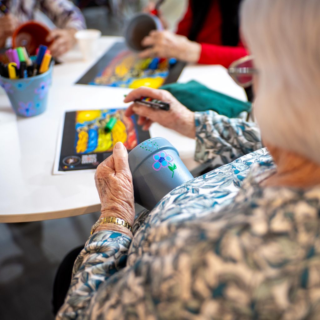 A residential aged care resident practises dot painting