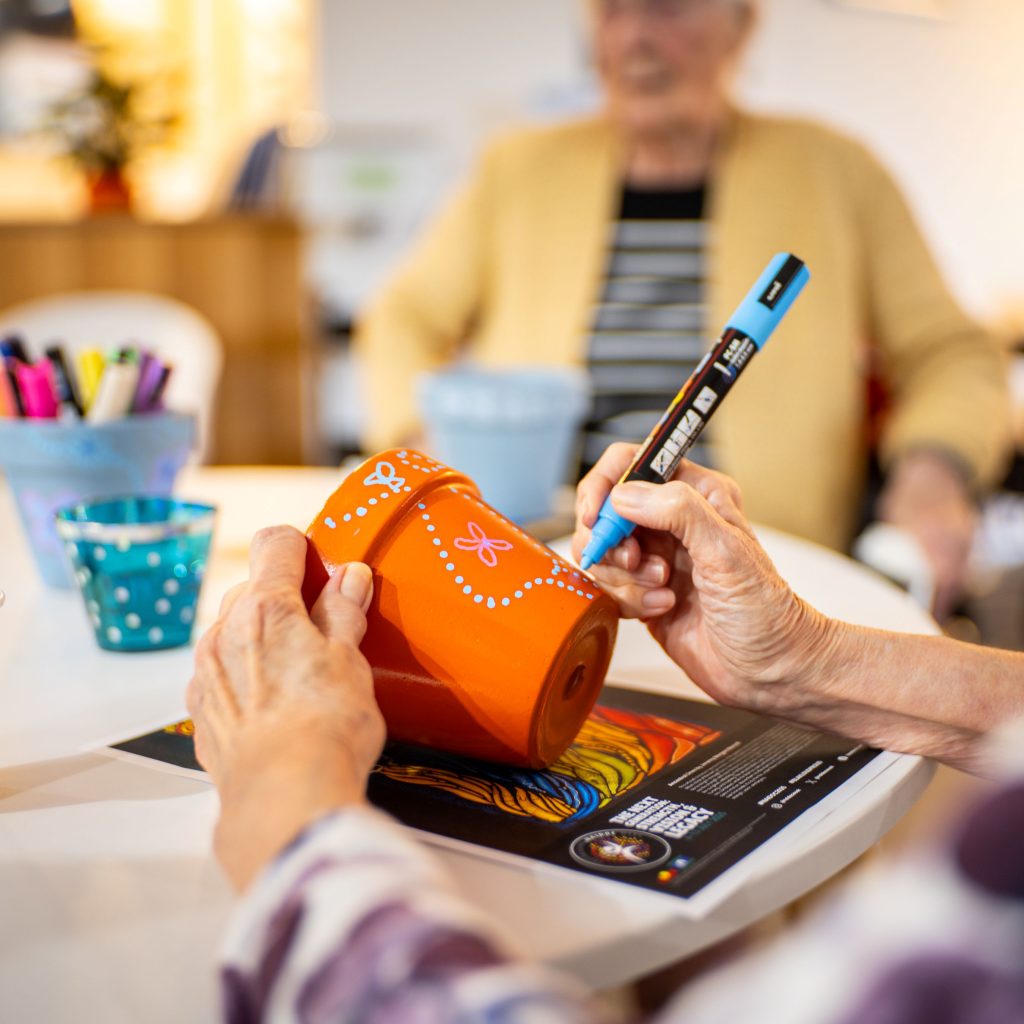 An aged care resident practises dot painting