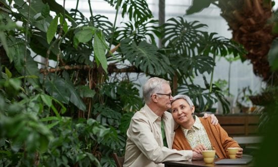 A couple embrace while sitting in front of a garden