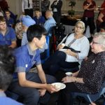 Churchie students and Anglicare residents sit in a large room for conversation