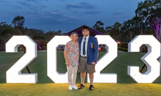 Mother and son standing in front of a "2023" sign