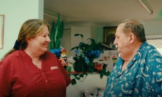 A man and woman engage in conversation in a living room